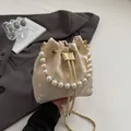 Elegant off-white bucket bag with butterfly jacquard, pearl handle, and chain strap - Beige