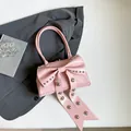 Schicke rosa Handtasche mit großer Schleife, Silbernieten und elegantem Tragegriff - Rosa