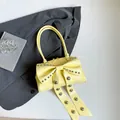 Lichtgele laks lederen handtas met grote strik en zilveren studs decoratie - Geel