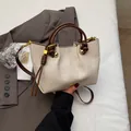 Elegante borsa a mano color crema con cinturini marroni e accenti dorati - Bianco Sporco
