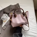 Secchiello intrecciato rosa con tracolla in pelle marrone e dettagli dorati - Rosa