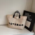 Beige geweven strooien draagtas met zwarte hengsels en TOTEBAG-belettering - Zwart