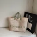 Minimalistische beige rieten draagtas met groene handvaten en TOTEBAG-tekst voor de zomer - Groen