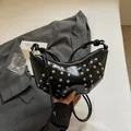 Borsa a mezzaluna in pelle verniciata nera con borchie argentate e dettagli annodati - Nero