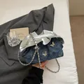 Borsa a secchiello in denim blu con ciondoli a farfalla e catena metallica - Blu Denim