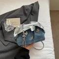 Borsa a secchiello in denim blu con ciondoli a farfalla e tracolla a catena - Celeste