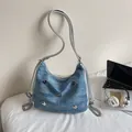 Sac hobo en jean bleu clair avec détails papillons argentés et bandoulière chaîne - Bleu Denim