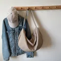 Brown gingham checkered crescent tote bag hanging with denim jacket for commute - Plaid Pattern / Apricot