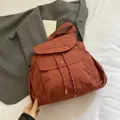 Mochila de lona marrón rojizo con letras bordadas y cordones de ajuste a rayas - Rojo