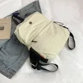 Mochila de nailon blanco crema con correas negras y logo metálico para viajes casuales - Blanco