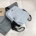 Hellblauer Freizeitrucksack aus Nylon mit Metalllogo auf weißem Bettlaken Hintergrund - Blau