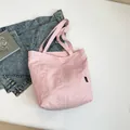 Pink minimalist nylon tote bag shown with casual denim jacket on white background - Pink