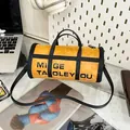 Yellow cylinder crossbody bag with shoulder strap in a stylish office setup - Cylindrical / Yellow