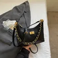 Schicke schwarze Stepptasche mit goldenem Drehverschluss und eleganter Kettenschulter - Schwarz