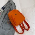 Mini-Rucksack in Orange aus Nylon mit lächelndem Metalllogo und Trägern - Orange