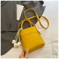 Mini-Eimertasche in Gelb aus weichem PU-Leder mit Tulpenanhänger und Schultergurt - Gelb mit Anhänger