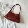 Primer plano del bolso de hombro trenzado rojo oscuro con tejido estilo Intrecciato - Rojo