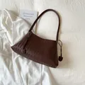 Detalle del bolso de hombro tejido a mano en marrón oscuro con textura de cuero Intrecciato - Marrón
