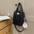 Black nylon crossbody bag with cute bow pocket and colorful plush heart charm - With Charm / Black