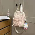Pink canvas mini handbag with bow drawstring and colorful plush monster keychain charm - With Charm / Pink