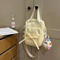 Light yellow stylish shoulder bag with bow detail and cute colorful plush monster charm - With Charm / Yellow