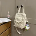 Cream nylon handbag with cute ribbon bow and colorful plush monster pendant charm - With Charm / Off White