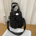 Black nylon crossbody bag featuring stylish pleated bow and convenient zippers - No Pendant / Black