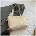 Bolso tote beige con estampados de osos y correas largas en un entorno elegante - Blanco