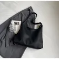 Minimalistische schwarze Beuteltasche aus Leder mit breitem Riemen und großem Volumen - Schwarz