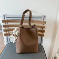 Braune Beuteltasche aus Leder mit Kieselprägung und süßem Plüschhund-Anhänger - Braun mit Anhänger
