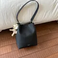 Modische schwarze Eimertasche mit Litschi-Textur und süßem Bären-Anhänger - Schwarz mit Anhänger