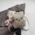 Mochila beige de cuero arrugado con cadenas plateadas y un colgante de felpa - Blanco Roto