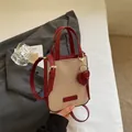 Mini bolso bandolera de lona beige y cuero rojo con colgante de corazón y asa - Rojo