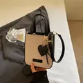 Bolso pequeño bandolera beige tejido y cuero negro con colgante de corazón - Negro