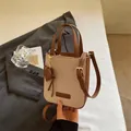 Beige canvas and brown leather crossbody bag with adjustable strap and heart charm - Brown