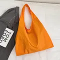 Large bright orange canvas tote bag with a minimalist integrated shoulder strap design - Orange