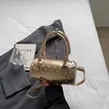 Polka dot cylinder handbag in metallic champagne gold with top handles and shoulder strap - Gold