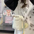 Minimalistische crème witte crossbodytas met trekkoord, olifantenbedeltje en geweven riem - Crèmewit Met Hanger