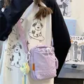 Lichtpaarse vierkante crossbodytas van nylon met een gele pluche hanger eraan - Paars Met Hanger