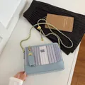 Blue striped crossbody bucket bag with gold chain strap and bear charm accessory - Blue