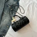 Black quilted barrel bag with chain strap and yellow lace bow decoration on handle - Black