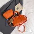 Orange lychee grain leather underarm bag with a matching pouch and lion charm accessory - With Pendant / Orange