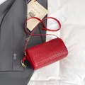 Red woven cylinder crossbody bag made of soft leather with adjustable gold hardware - Red