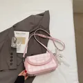 Pink checkered baguette bag with lace bow and adjustable strap in a lifestyle setting - Pink With Pendant