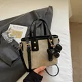 Mini sac seau en tissu beige texturé avec bordure en cuir noir et breloque chiot - Avec Pendentif / Blanc Cassé