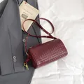 Burgundy woven leather cylinder shoulder bag with golden hardware and adjustable strap - Burgundy