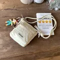 Borsa a secchiello in nylon beige con tracolla in corda e ciondolo a bambolina - Bianco Sporco