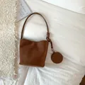 Brown suede-texture bucket shoulder bag with slim strap and round coin purse charm - Brown