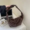 Bolso hobo grande marrón oscuro con textura litchi y correa ajustable en una oficina - café
