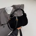 Elegante zwarte suède halve maanstas met geknoopte handgreep en gouden gesp detail - Zwart